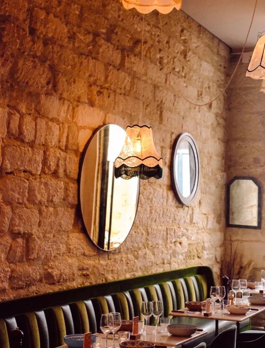 Salle de Disco Volante : mur en pierre, miroirs chinés et banquette de velours